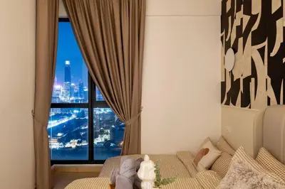 a bedroom with a bed with a view of a city at KidsVille Shamelin Star KLCC View Infinity Pool in Kuala Lumpur