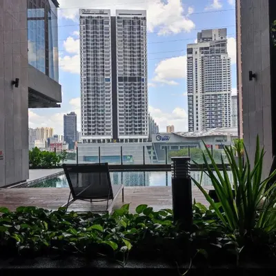 a chair sitting on a balcony with a view of a city at Anggun residence studio klcc in Kuala Lumpur
