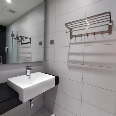 a white bathroom with a sink and a mirror at Anggun residence studio klcc in Kuala Lumpur