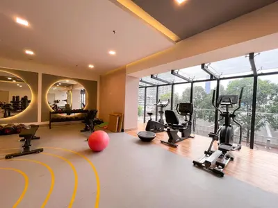 a gym with treadmills and exercise equipment in a room with windows at The Little Bali - Karaoke - 4 Pax in Kuala Lumpur