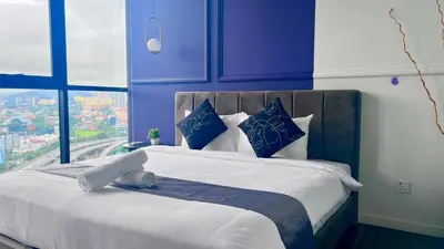 a bedroom with a large bed with blue and white pillows at Scarletz Suites KLCC by Minshuku in Kuala Lumpur