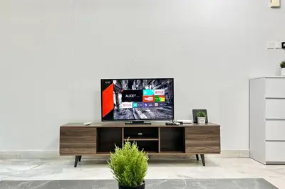 a tv sitting on top of a wooden entertainment center at 3BR Family Stay at Desa Pandan KL ready Wifi Netflix in Kuala Lumpur