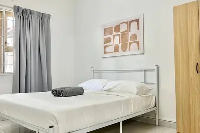 a white bedroom with a bed with a black towel on it at 3BR Family Stay at Desa Pandan KL ready Wifi Netflix in Kuala Lumpur