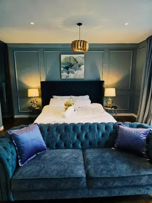 a bed with a blue couch in a bedroom at Anggun Residence near KLCC Serviced Suite in Kuala Lumpur