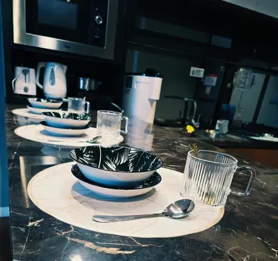 a kitchen counter with plates and bowls and spoons at Anggun Residence near KLCC Serviced Suite in Kuala Lumpur