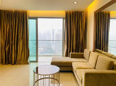 a living room with a couch and a glass table at Regalia KLCC View by Ucare Suites in Kuala Lumpur