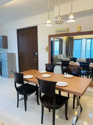 a dining room with a wooden table and chairs at Regalia KLCC View by Ucare Suites in Kuala Lumpur
