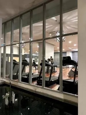 a gym with a reflection of a man in a mirror at Regalia KLCC View by Ucare Suites in Kuala Lumpur