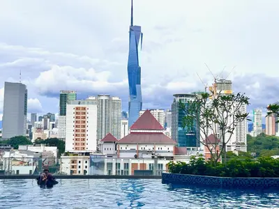 a man sitting in the water in front of a city at KL Sentral 28th Floor CityCenter in Kuala Lumpur
