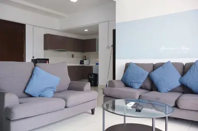 a living room with two couches and a glass table at Awesomestay Hostel near KLCC , walk to PWTC PUTRA in Kuala Lumpur