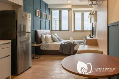 a living room with a bed and a table in a kitchen at Riveria City at KL Sentral by Plush in Kuala Lumpur