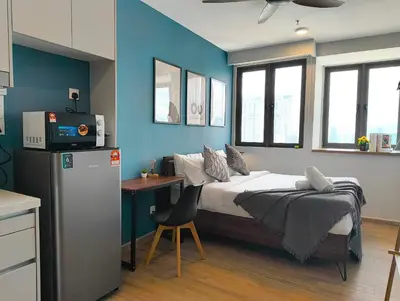 a bedroom with a bed and a desk with a television at Riveria City at KL Sentral by Plush in Kuala Lumpur