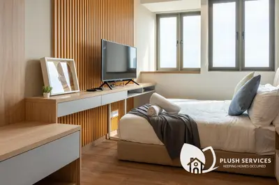 a bedroom with a bed and a desk with a television at Riveria City at KL Sentral by Plush in Kuala Lumpur