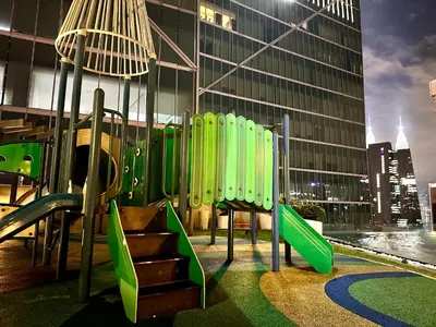 a playground with green equipment in front of a building at Dorsett Bukit Bintang with Bathtub by Prestige in Kuala Lumpur