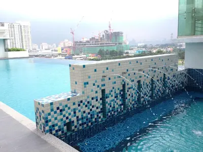 a building with a pool of water in a city at Setapak Central KL - Zetapark Spring Suites in Kuala Lumpur