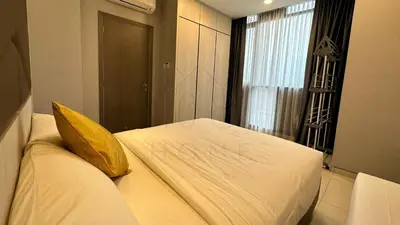 a bedroom with a bed with a yellow pillow and a window at Societe Suites 108 Hartamas Mont Kiara Kuala Lumpur 2-6pax in Kuala Lumpur