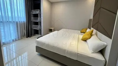 a bedroom with a bed with white sheets and yellow pillows at Societe Suites 108 Hartamas Mont Kiara Kuala Lumpur 2-6pax in Kuala Lumpur
