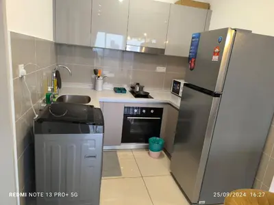 a small kitchen with a refrigerator and a sink at Trion by sweet home in Kuala Lumpur