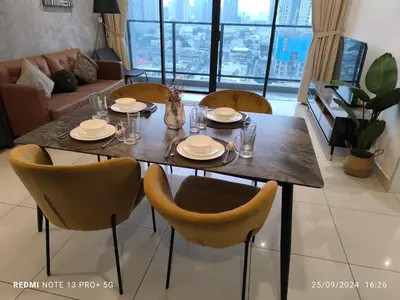 a dining room table and chairs with plates and glasses at Trion By Awesome Apartment Stay in Kuala Lumpur