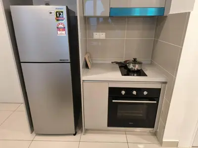 a small kitchen with a refrigerator and a stove at Trion By Awesome Apartment Stay in Kuala Lumpur