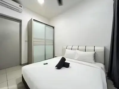 a white bed with a black remote control on it at Trion By Awesome Apartment Stay in Kuala Lumpur