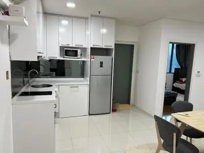 a kitchen with a refrigerator and a table in a room at Summer Suites KLCC in Kuala Lumpur