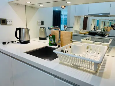 a kitchen counter with a dish drying rack and a sink at Vortex Hotel Suites & Residence by KLCC in Kuala Lumpur