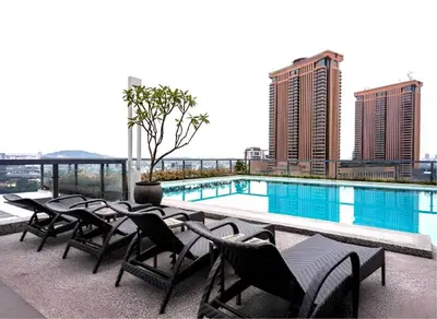 a group of chairs and a swimming pool on a building at Bintang Fairlane Residence, KLCC & City View - 2B1R in Kuala Lumpur