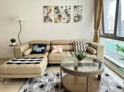 a living room with a couch and a glass table at Bintang Fairlane Residence, KLCC & City View - 2B1R in Kuala Lumpur