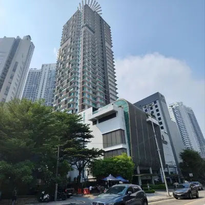 a tall building with cars parked in a city at Swiss Garden Bukit Bintang in Kuala Lumpur