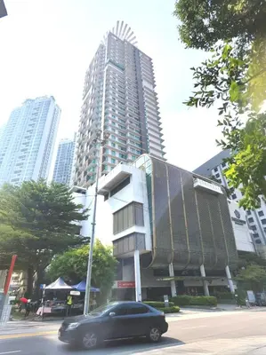 a black car driving down a street in front of a tall building at Swiss Garden Bukit Bintang in Kuala Lumpur
