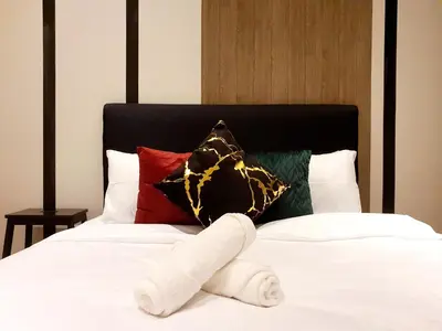 a stuffed animal is laying on a bed at The Mews KLCC by GBS in Kuala Lumpur