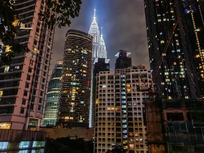 a group of tall buildings in a city at night at The Mews KLCC by GBS in Kuala Lumpur