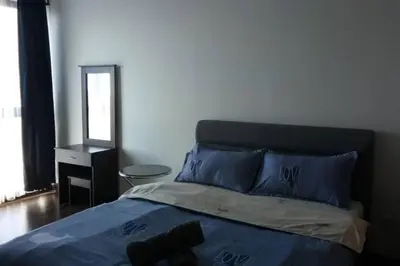 a bedroom with a bed with blue pillows and a mirror at V Residence Suite at Sunway Velocity in Kuala Lumpur