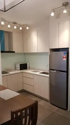 a kitchen with a stainless steel refrigerator and a table at V Residence Suite at Sunway Velocity in Kuala Lumpur