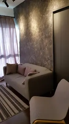 a living room with a couch and a wall at V Residence Suite at Sunway Velocity in Kuala Lumpur