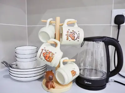 a group of coffee cups and plates on a kitchen counter at Capybara Trion KL View in Kuala Lumpur