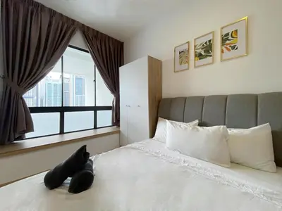 a black teddy bear laying on a bed with a window at Colony Infinitum By NJ Homes in Kuala Lumpur