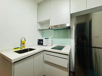 a kitchen with white cabinets and a stainless steel refrigerator at Awesomestay apartment walk to Tun Sambathan near KL Sentral in Kuala Lumpur