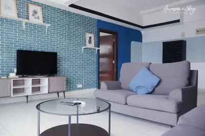 a living room with a couch and a tv at NJ Homestay Hostel at Regalia Residence in Kuala Lumpur