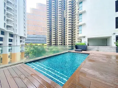 a swimming pool in the middle of a building with tall buildings at NJ Homestay Hostel at Regalia Residence in Kuala Lumpur