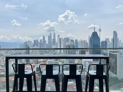a view of a city skyline from a table and chairs at NJ Homestay Hostel at Regalia Residence in Kuala Lumpur