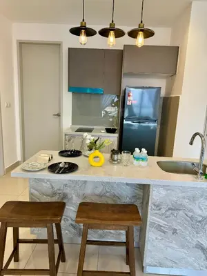 a kitchen with a counter with two chairs and a refrigerator at trion2 klcc in Kuala Lumpur