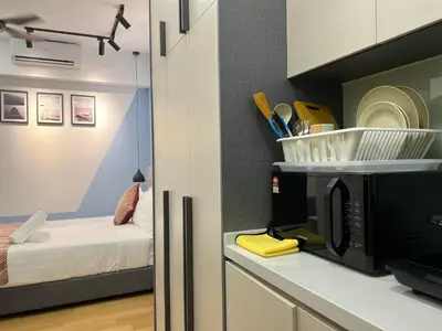 a kitchen with a microwave and a room with a bed at The Colony By Infinitum KLCC in Kuala Lumpur