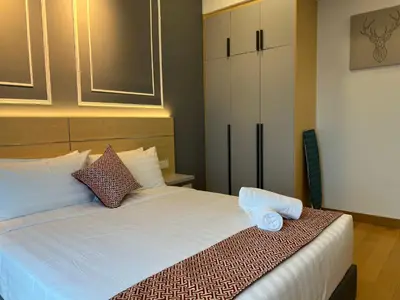 a bedroom with a white bed with two towels on it at The Colony By Infinitum KLCC in Kuala Lumpur