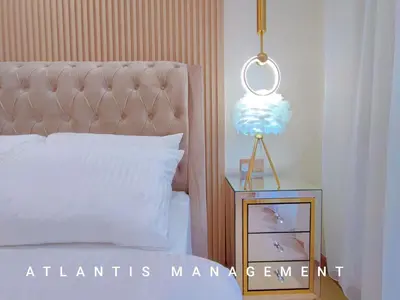 a bedroom with a bed and a night stand with a lamp at Arte Mon Kiara MK3 Royal Stylist Apartment, Walking Distance to Publika in Kuala Lumpur