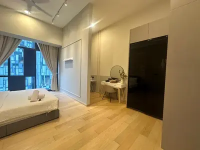 a bedroom with a bed and a desk with a mirror at Holiday Suites at Star in Kuala Lumpur