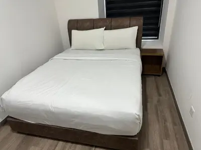 a bed with a wooden headboard in a room at Agile Residence Bukit Bintang TRX By SweetHome in Kuala Lumpur