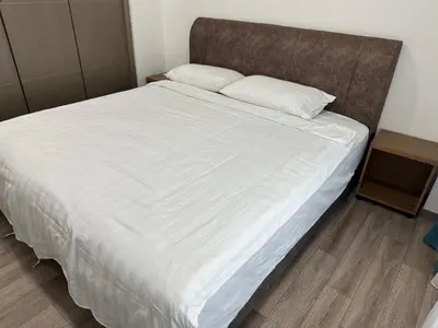 a large bed with white sheets and a wooden headboard at Agile Residence Bukit Bintang TRX By SweetHome in Kuala Lumpur