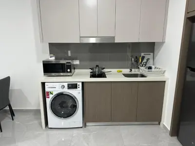 a kitchen with a washing machine and a microwave at Agile Residence Bukit Bintang TRX By SweetHome in Kuala Lumpur